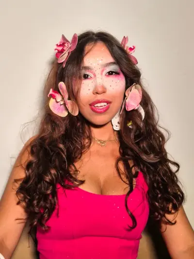 Maquiagem criativa com flores no cabelo cacheado